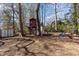 The backyard offers a treehouse, fire pit, seating area, and mature trees for shade at 5033 Green Oak Dr, Durham, NC 27712