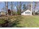 Expansive backyard featuring a detached garage, mature trees, and a charming playhouse at 5033 Green Oak Dr, Durham, NC 27712