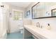 Bright bathroom featuring a white tiled tub, toilet and sink with blue tiled floors and window with natural light at 5033 Green Oak Dr, Durham, NC 27712