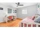 Bright bedroom featuring a daybed, a desk with a chair, two windows with natural light and wood floors at 5033 Green Oak Dr, Durham, NC 27712