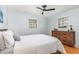 Cozy bedroom featuring hardwood floors, a comfortable bed, dresser, ceiling fan and two windows with natural light at 5033 Green Oak Dr, Durham, NC 27712