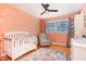 Charming Bedroom featuring an area rug, crib, chair, and a white dresser, accented by peach walls and natural light at 5033 Green Oak Dr, Durham, NC 27712