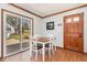 Cozy dining area with a wood table, four chairs, and sliding glass door leading to deck at 5033 Green Oak Dr, Durham, NC 27712