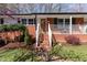 Inviting brick front porch with white railings and stairs leading to a wood front door with wreath at 5033 Green Oak Dr, Durham, NC 27712