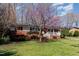 Inviting home exterior featuring a well-manicured lawn, mature trees, and charming front porch at 5033 Green Oak Dr, Durham, NC 27712