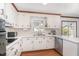 Bright kitchen featuring white cabinets, stainless steel appliances, and tile countertops at 5033 Green Oak Dr, Durham, NC 27712