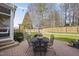 Landscaped backyard featuring a brick patio with outdoor seating and a manicured lawn with a swing at 504 Skygrove Dr, Holly Springs, NC 27540