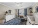 Cozy Bedroom with a white dresser, crib, area rug, and ample natural light at 504 Skygrove Dr, Holly Springs, NC 27540