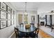 Cozy dining area with black table, stylish chandelier, and doorway to living room with fireplace at 504 Skygrove Dr, Holly Springs, NC 27540