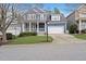 Charming two-story blue home with a welcoming front porch and well-manicured lawn at 504 Skygrove Dr, Holly Springs, NC 27540