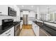 Stylish kitchen with stainless steel appliances, white cabinets, and dark countertops at 504 Skygrove Dr, Holly Springs, NC 27540