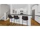 Kitchen with seating at counter, white cabinets, and stainless steel appliances at 504 Skygrove Dr, Holly Springs, NC 27540