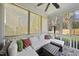 Relaxing screened porch featuring a plush white sectional and natural sunlight at 504 Skygrove Dr, Holly Springs, NC 27540