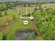 Expansive property featuring a pond and multiple outbuildings surrounded by lush greenery at 5069 Cokesbury Rd, Fuquay Varina, NC 27526