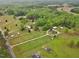 Sprawling country estate showcasing multiple homes, barns, and lush green pastures surrounded by a dense tree line at 5069 Cokesbury Rd, Fuquay Varina, NC 27526