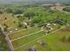 Aerial view of a large parcel of land featuring multiple buildings, pastures, and boundary line at 5069 Cokesbury Rd, Fuquay Varina, NC 27526