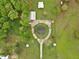 Overhead view of a beautiful country home surrounded by lush landscaping and circular driveway and outbuildings at 5069 Cokesbury Rd, Fuquay Varina, NC 27526