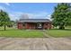 Charming log cabin home with a well-manicured lawn and inviting front porch area with a concrete drive at 5069 Cokesbury Rd, Fuquay Varina, NC 27526