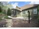 View of the home's backyard, featuring a screened-in porch, landscaped yard, and stone patio at 515 Bexley Bluff Ln, Cary, NC 27513