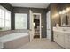 A luxurious bathroom features a soaking tub, double vanity, and an open doorway to the Primary bedroom at 515 Bexley Bluff Ln, Cary, NC 27513