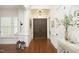 Elegant foyer featuring dark wood floors, white trim, plantation shutters and stylish decor with double front doors at 515 Bexley Bluff Ln, Cary, NC 27513
