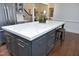 A modern kitchen island features ample storage and a large white countertop, perfect for meal prep and dining at 515 Bexley Bluff Ln, Cary, NC 27513