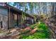 Exterior side view of home with brick pathway, wooded backyard and garden area at 518 Morgan Creek Rd, Chapel Hill, NC 27517