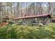 Long, ranch-style home with a rusty metal roof and a large, inviting deck in a wooded setting at 518 Morgan Creek Rd, Chapel Hill, NC 27517