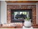 Close-up of a traditional brick fireplace with a black mesh screen at 518 Morgan Creek Rd, Chapel Hill, NC 27517