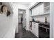 Well-lit hallway with white cabinets, black countertop, black slate tile, and a laundry area at 518 Morgan Creek Rd, Chapel Hill, NC 27517