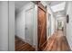 Hallway with hardwood floors, a skylight, and a rustic sliding barn door adding charm at 518 Morgan Creek Rd, Chapel Hill, NC 27517