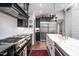 Modern kitchen featuring black cabinets, white backsplash, and stainless steel appliances at 518 Morgan Creek Rd, Chapel Hill, NC 27517