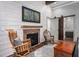 Cozy living room with brick fireplace, mounted TV, shiplap wall and rustic decor at 518 Morgan Creek Rd, Chapel Hill, NC 27517