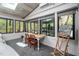 Cozy sunroom featuring a dining table, large windows, and scenic views of the surrounding landscape at 518 Morgan Creek Rd, Chapel Hill, NC 27517