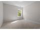 Neutral bedroom featuring a window for natural light and plush carpeting at 5209 Woodlawn Dr, Durham, NC 27703