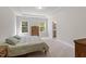 Bright and inviting bedroom featuring a comfortable bed, carpeted floors, and ample natural light from the two windows at 5209 Woodlawn Dr, Durham, NC 27703
