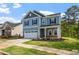 Two-story blue home with a two-car garage and a cozy front porch nestled in a landscaped neighborhood at 5209 Woodlawn Dr, Durham, NC 27703