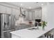 Modern kitchen with stainless steel appliances, gray cabinets, white backsplash, and a large island at 5209 Woodlawn Dr, Durham, NC 27703