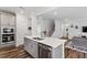 Open kitchen with stainless appliances, quartz countertops, and access to living and dining areas at 5209 Woodlawn Dr, Durham, NC 27703