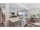 Bright kitchen featuring gray cabinets, stainless steel appliances, quartz countertops, and an island with seating at 5209 Woodlawn Dr, Durham, NC 27703