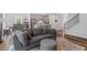 Cozy living room featuring a modern kitchen with stainless steel appliances, gray cabinets, and hardwood floors at 5209 Woodlawn Dr, Durham, NC 27703