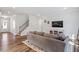 Comfortable living room with a large TV, hardwood floors and a staircase with wooden handrail at 5209 Woodlawn Dr, Durham, NC 27703