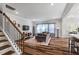 Cozy living room with hardwood floors, staircase with iron railing, and neutral decor leading to dining space at 5209 Woodlawn Dr, Durham, NC 27703