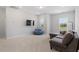 Bright living room with large windows, comfortable seating, and a mounted TV at 5209 Woodlawn Dr, Durham, NC 27703