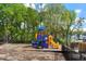 Community playground area with brightly colored play equipment and a surrounding safety fence at 5209 Woodlawn Dr, Durham, NC 27703