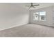 Bright bedroom featuring a modern ceiling fan and large windows offering natural light and neighborhood views at 5712 Agrinio Way, Raleigh, NC 27603