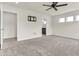 A blank canvas carpeted bedroom features a ceiling fan, multiple doorways, and natural light at 5712 Agrinio Way, Raleigh, NC 27603