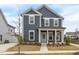 Charming two-story home with a covered front porch, blue siding, white trim, and well-maintained landscaping at 5712 Agrinio Way, Raleigh, NC 27603