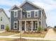 Attractive two-story home with blue siding, white trim, and a welcoming front porch with classic pillars at 5712 Agrinio Way, Raleigh, NC 27603