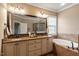 A bathroom featuring double sinks, granite countertops, a large mirror, and a soaking tub at 603 Goal Kick Dr, Fuquay Varina, NC 27526